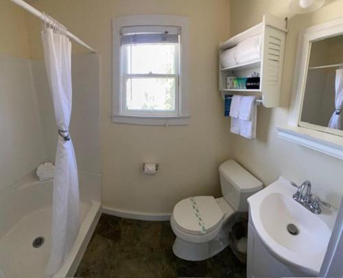 a bathroom with a toilet and a sink and a window at Cherokee Lodge in San Diego