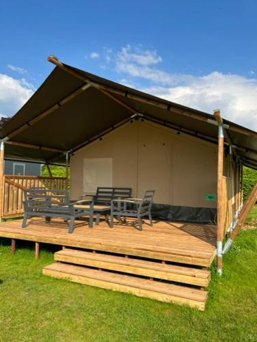 a deck with two chairs and a table and a tent at Safaritent 2 in Swalmen