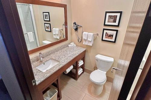 a bathroom with a sink and a toilet and a mirror at Baymont by Wyndham Phoenix North in Phoenix