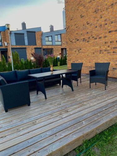 a patio with a table and chairs and a couch at Dainiaus Apartamentai in Palanga