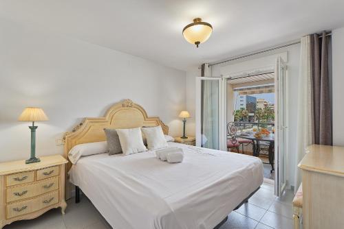 sypialnia z dużym białym łóżkiem i balkonem w obiekcie Sandy Beach w Maladze