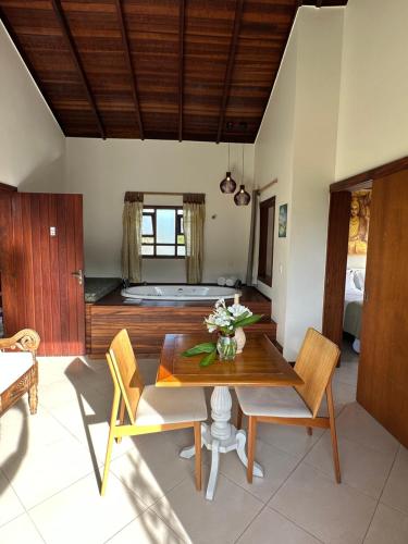 a dining room with a table and chairs and a bed at Residencial Villa Cris in Bertioga