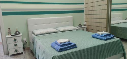 Un dormitorio con una cama con toallas azules. en Room Rome, en Roccella Ionica