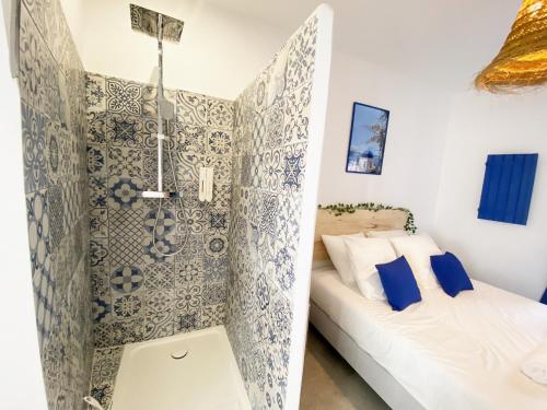 a bathroom with a shower and a bed in a room at Le Santorini - centre ville & terrasse privée in Béthune