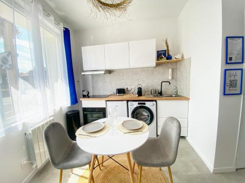 una pequeña cocina con mesa blanca y sillas en Le Santorini - centre ville & terrasse privée, en Béthune