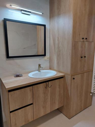 a bathroom with a sink and a mirror at Guest House Planinic in Čitluk