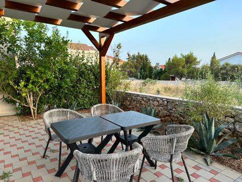 a picnic table and chairs on a patio at MINT Novalja Apartments in Novalja