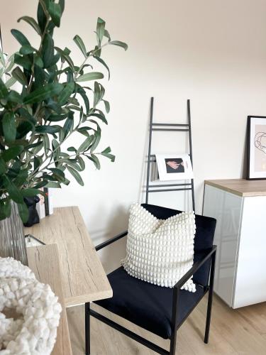 a black chair with a pillow on it next to a table at Ferienwohnung Domizil am Delft II Emden in Emden