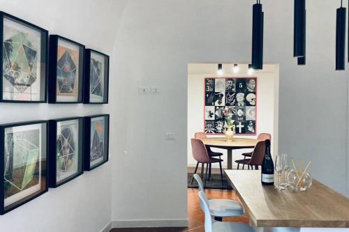 a dining room with a table and chairs and pictures on the wall at Palestro 8_Art Holiday House in Caramanico Terme