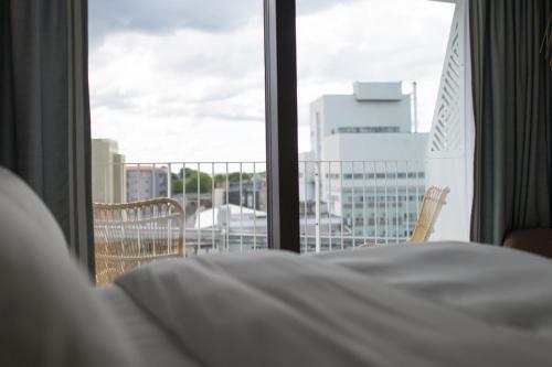 a bedroom with a bed and a view of a city at Hotel Riviera in Moss