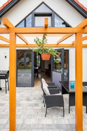a wooden pergola with a potted plant on a patio at Domki Górkło in Górkło