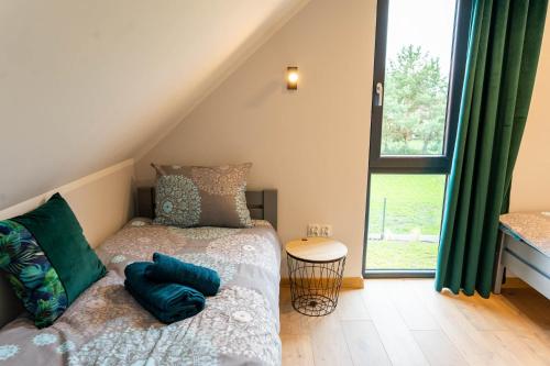 a small bedroom with a bed and a window at Domki Górkło in Górkło
