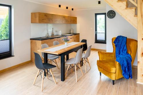 a kitchen and dining room with a table and chairs at Domki Górkło in Górkło