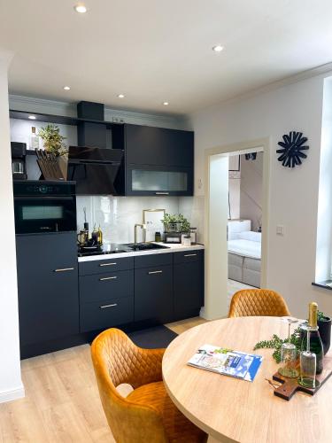 a kitchen with a wooden table and a dining room at Ferienwohnung Domizil am Delft II Emden in Emden