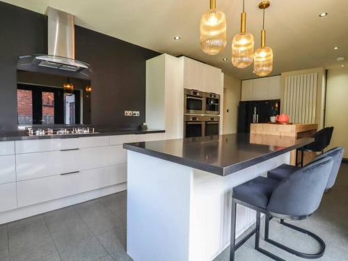 a kitchen with a large island with a black counter top at Beautiful home with hot tub near Cambridge in Royston