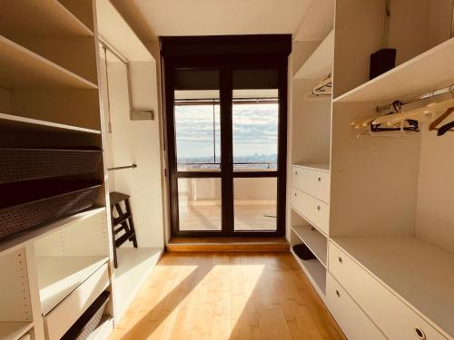 a walk in closet with a view of a window at MOZART RESIDENCE PLOIEȘTI Family and Business Apartment in Ploieşti