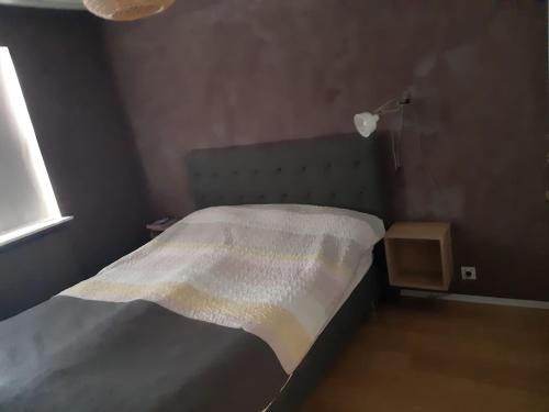 una camera da letto con un letto con una coperta bianca di Eiðistorg apt a Reykjavik