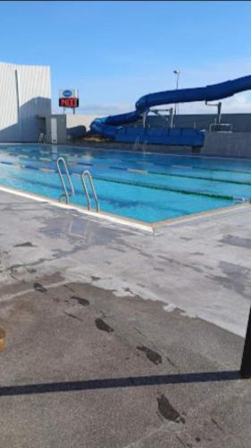 ein leerer Pool mit blauem Wasser in einem Gebäude in der Unterkunft Eiðistorg apt in Reykjavík