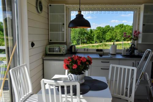 a kitchen with a table with a vase of flowers on it at Domek na Winnicy Zagrabie in Rybna