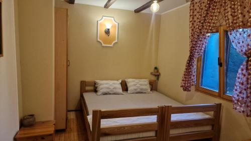 a bedroom with two beds and a window at Šumska bajka in Bajina Bašta