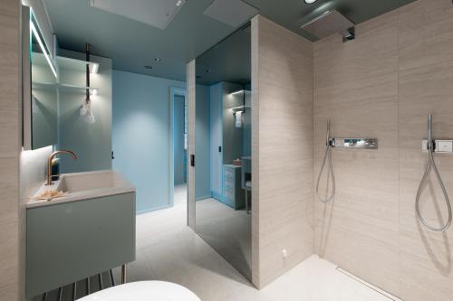 uma casa de banho com um chuveiro e um lavatório. em Hotel Riviera em Moss