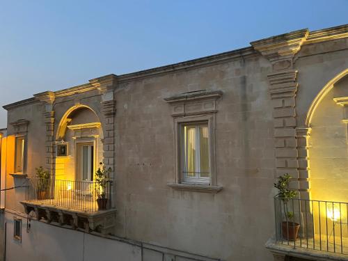 un edificio con due finestre e piante in vaso di Palazzo Terra d'Otranto a Martano
