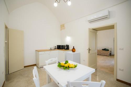 una sala da pranzo bianca con tavolo e sedie bianchi di Palazzo Terra d'Otranto a Martano