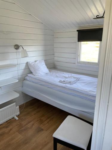 a bed in a small room with a window at 2 stugor, med panoramautsikt, paradis för fågelskådare och vandrare, självstäd efter besök in Mörbylånga