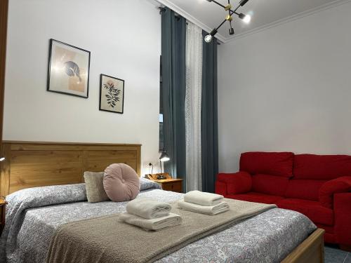- une chambre avec un lit et un canapé rouge dans l'établissement Piso ceferino, à Barreiros