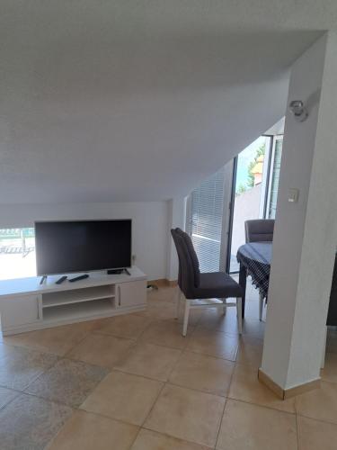 a living room with a flat screen tv and chairs at Apartments Pejanović in Kotor