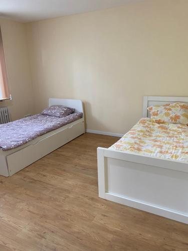 twee bedden in een kamer met houten vloeren bij FeWo Ibis in Bottrop