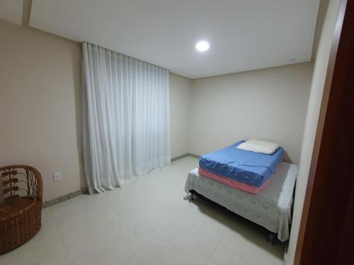 Un dormitorio con una cama en la esquina de una habitación. en Casa em Victor Hugo - 5 km do parque do china, en Domingos Martins
