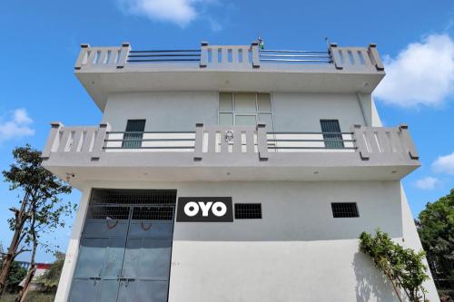OYO Flagship Amazing Inn في Murādnagar: مبنى أبيض مع علامة نجاح باهر عليه