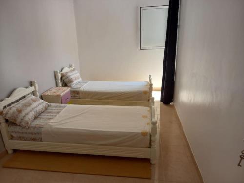 2 aparte bedden in een kamer met een muur bij Appartement Agadir Salam in Agadir