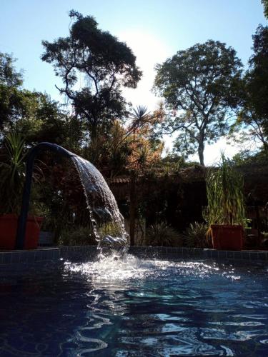 a water fountain in a swimming pool at Chalé Cores da Mata in Brumadinho