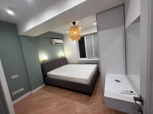 Habitación pequeña con cama y ventana en Two-bedroom apartment, en Bishkek
