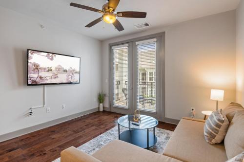 a living room with a couch and a ceiling fan at Comfy Retreat Balcony Views Amenities in Woodbridge