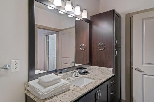 a bathroom with a sink and a large mirror at Comfy Retreat Balcony Views Amenities in Woodbridge