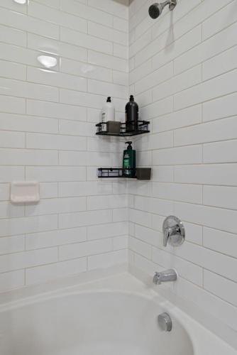 a white bathroom with a tub and a sink at Comfy Retreat Balcony Views Amenities in Woodbridge