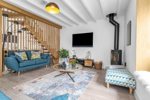 a living room with a blue couch and a tv at Luxury Riverside Retreat in Broughton