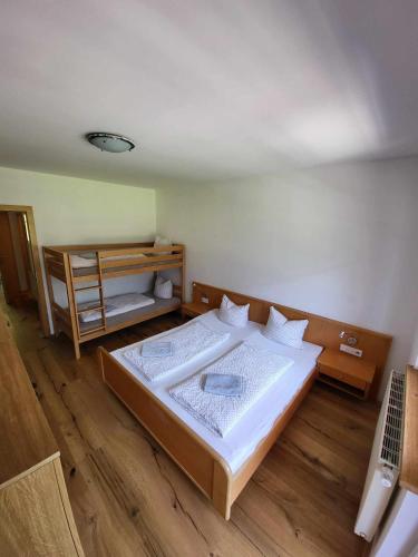 a bedroom with a large bed and a wooden floor at Apartment Mölltaler Gletscher 6 in Ausserfragant