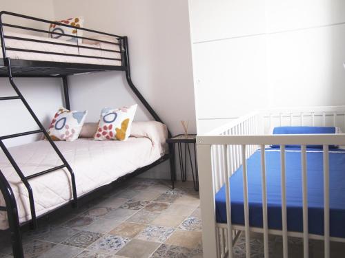 ein Schlafzimmer mit einem Etagenbett und einem Kinderbett in der Unterkunft Casa en l'Ampolla, patio y bbq, cerca de la playa. in L'Ampolla