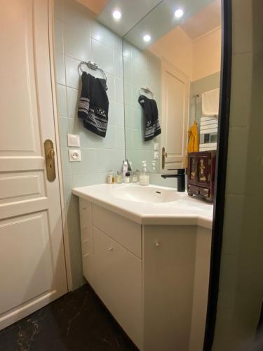 une salle de bain avec un lavabo et un miroir dans l'établissement Paris Eiffel Tower, à Paris
