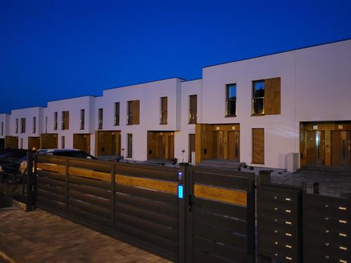 a row of buildings with wooden doors and a fence at Leszka Loft Apartment in Wodzisław Śląski