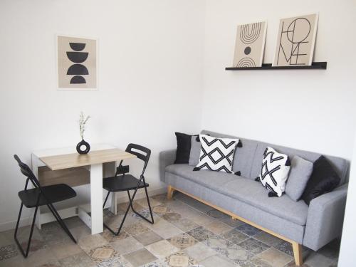 ein Wohnzimmer mit einem Sofa und einem Tisch in der Unterkunft Casa en l'Ampolla, patio y bbq, cerca de la playa. in L'Ampolla