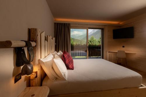a bedroom with a large bed with a window at Agriturismo San Gallo in Bormio