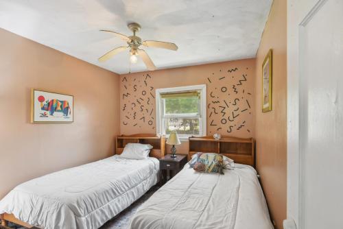um quarto com 2 camas e uma ventoinha de tecto em Cozy Massachusetts Escape with Patio, Near Beaches! em Fairhaven