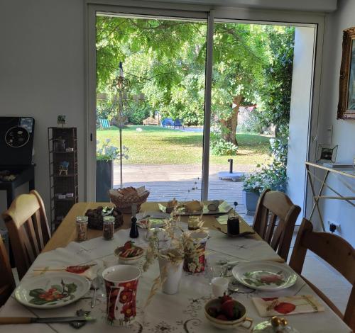 a table with plates of food on it with a window at LA VILLA MARIE in Richebourg