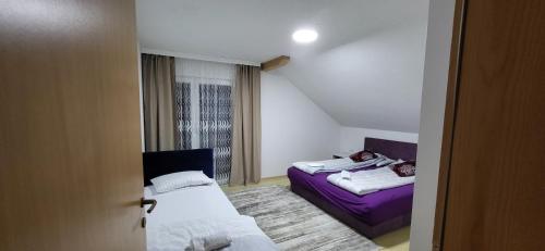 a small room with two beds and a window at Apartments Amina Sarajevo in Sarajevo