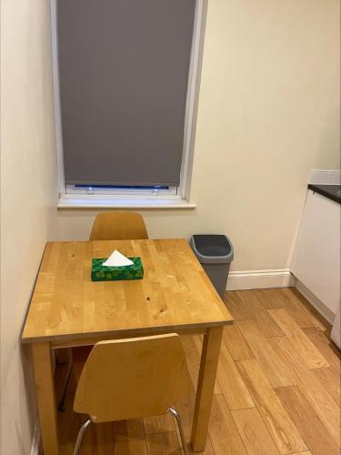 un tavolo e due sedie in una stanza con finestra di Sootheus - Soho71 a Londra